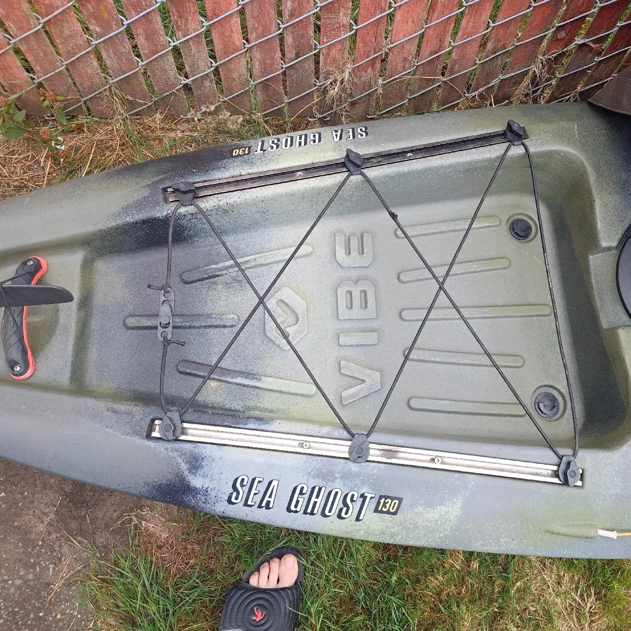 Kayak with 'Vibe' branding on a grassy area with a brick wall in the background.