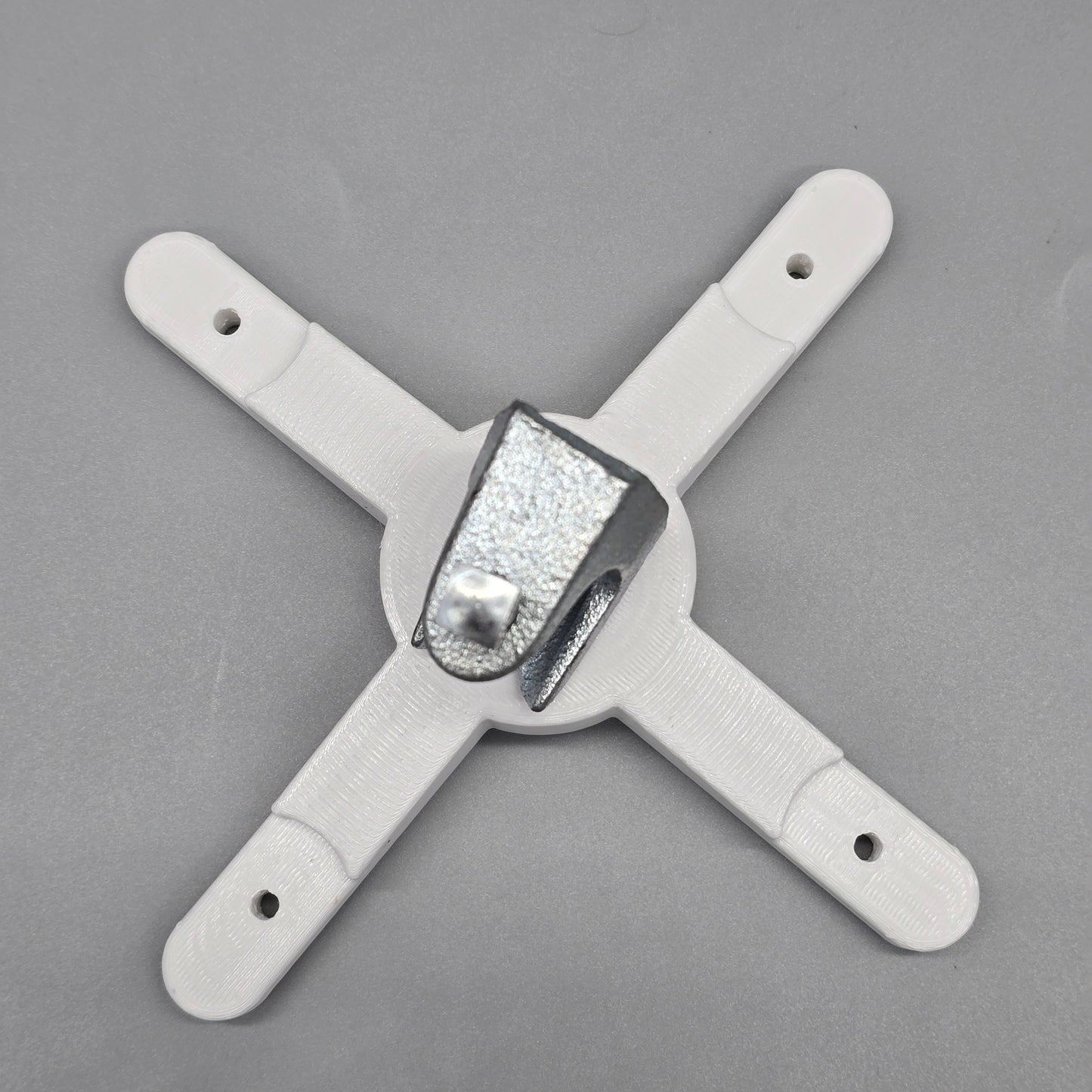 White plastic bracket with a central metallic component on a gray background