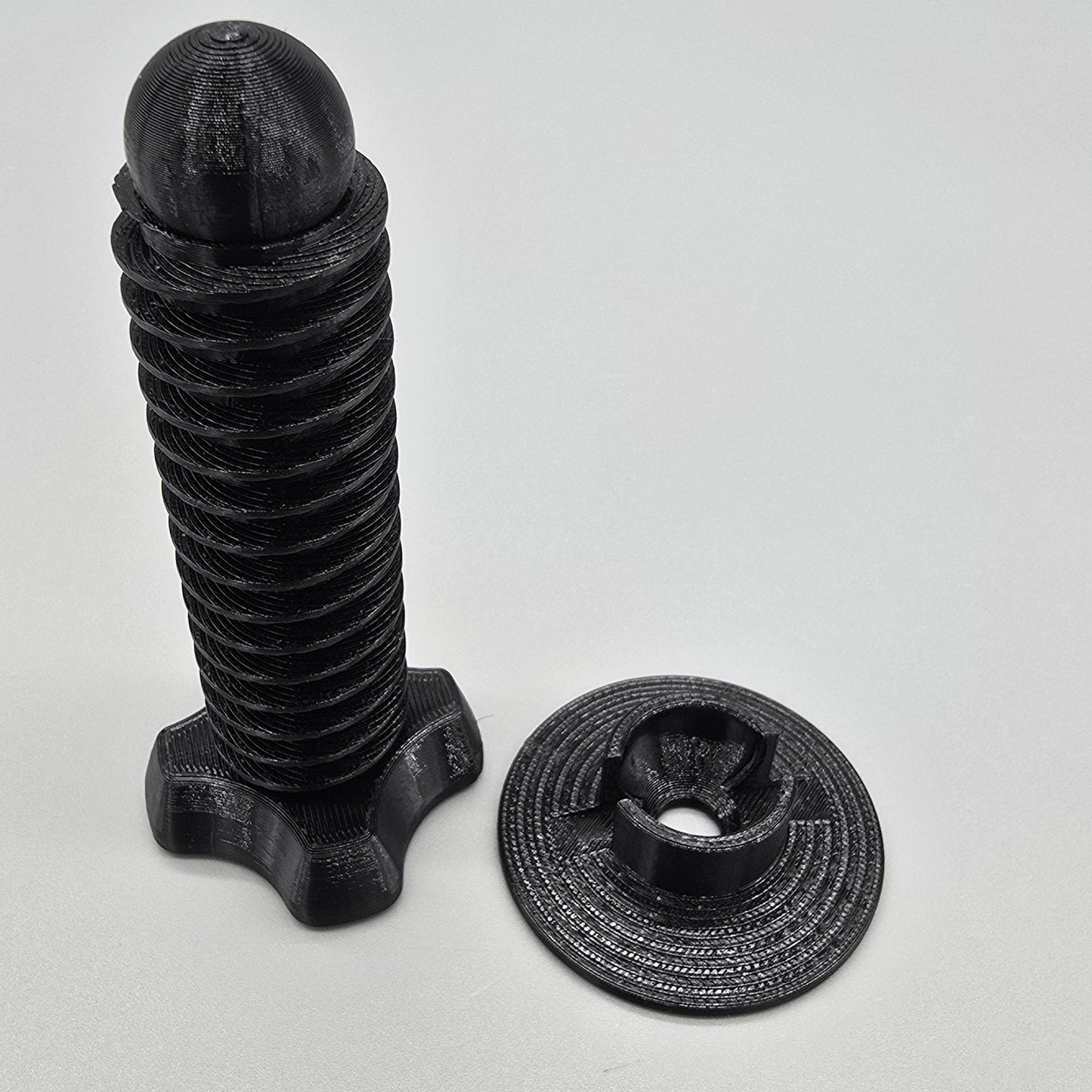 Black metal screw and nut on a light gray background