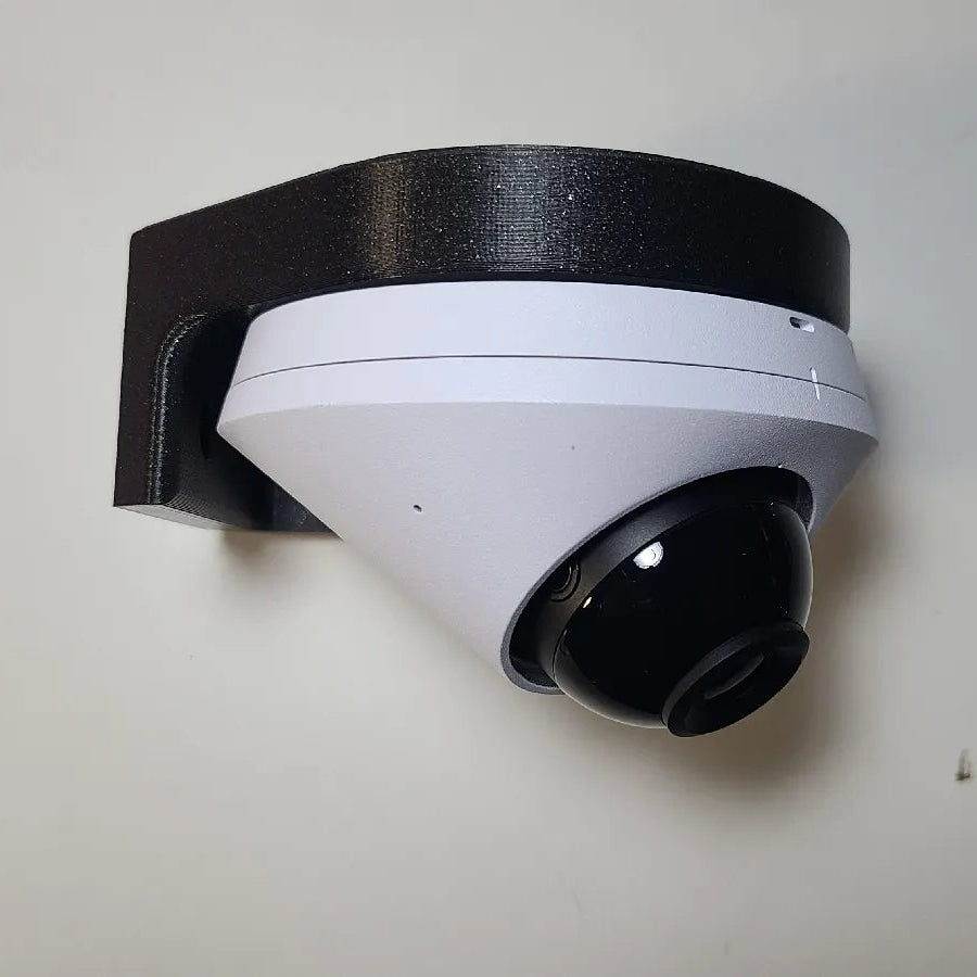 White security camera with black bracket on a light gray wall
