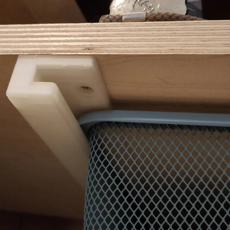 Close-up of a wooden shelf with a plastic corner protector and mesh side panel.