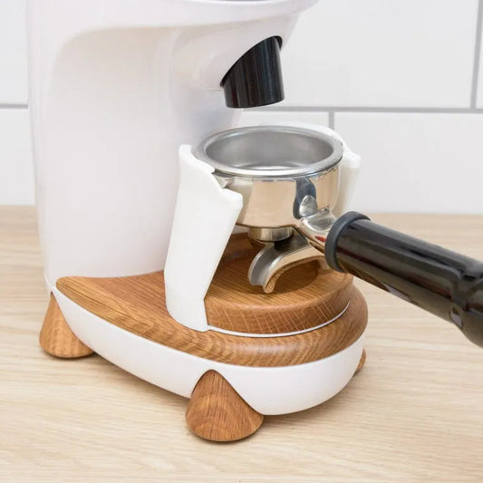 White espresso machine with wooden accents on a wooden surface.