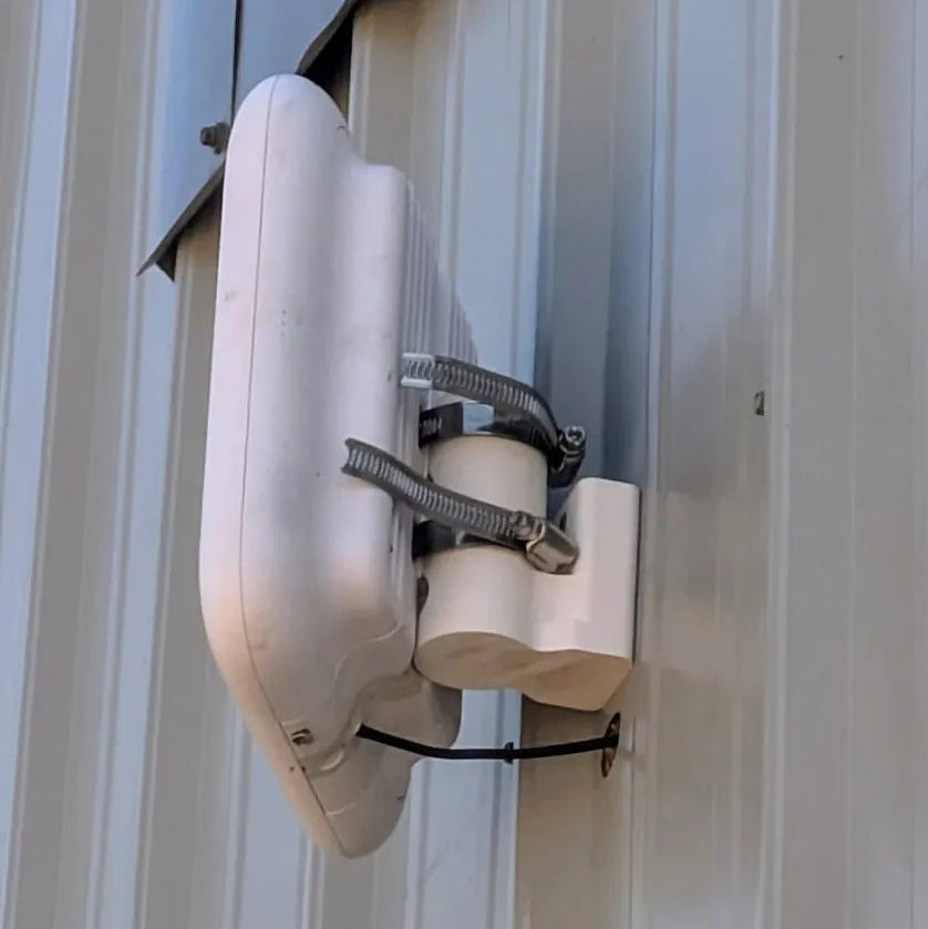 White satellite dish mounted on a metal wall