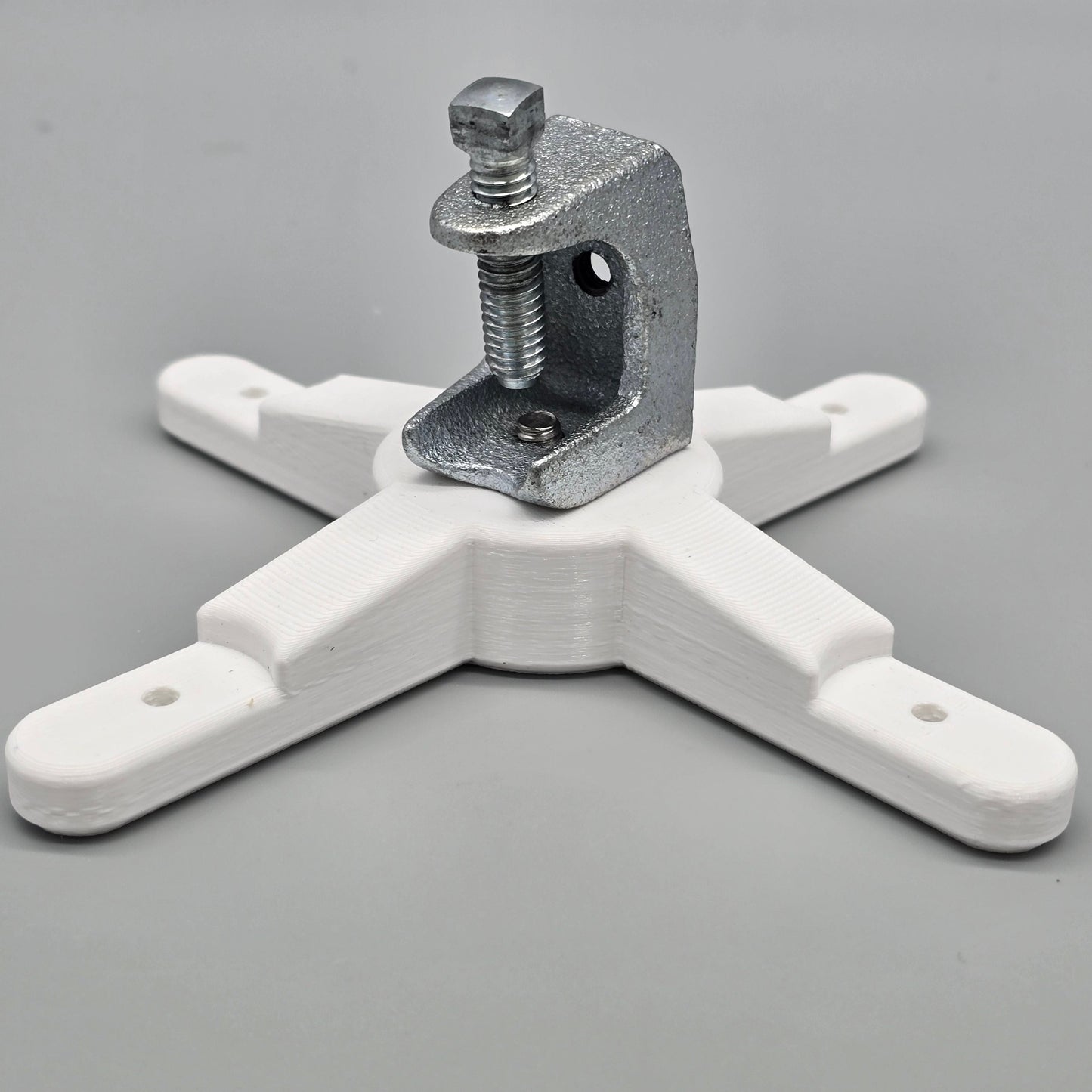 White plastic clamp with metal component on a gray background