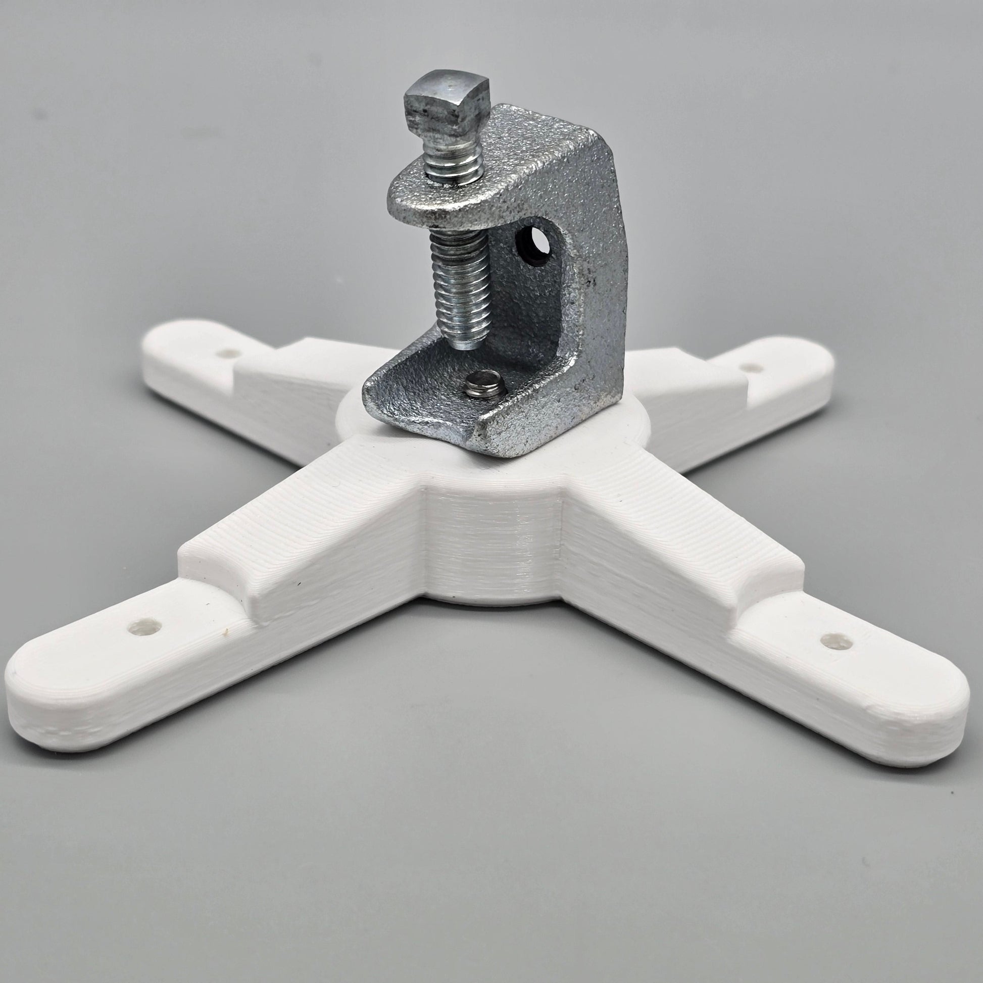 White plastic clamp with metal component on a gray background